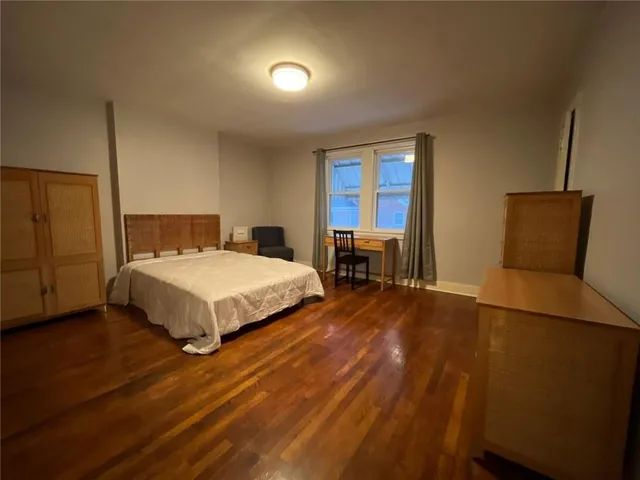 a bedroom with a bed chair and a window