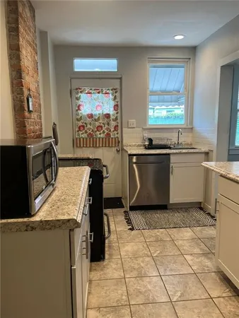 a kitchen with stainless steel appliances granite countertop a sink and a stove top oven