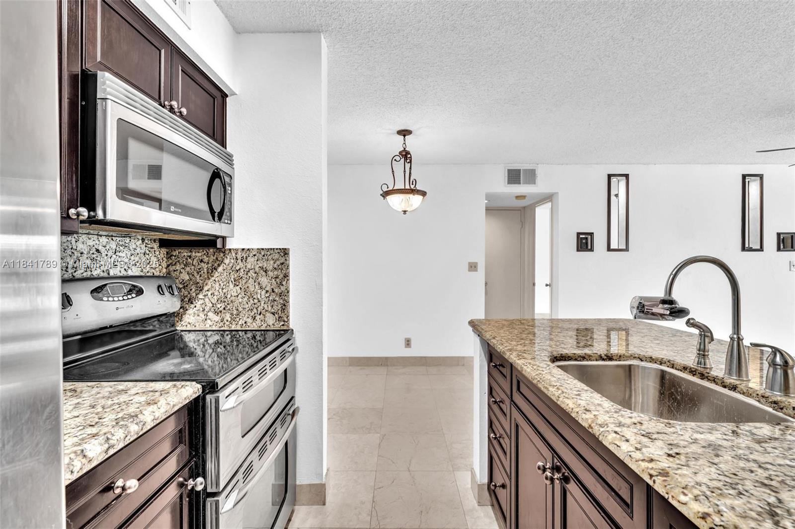 2796 South University Drive, Unit 2104 Davie, FL 33328 - Photo 11 of 41 a kitchen with granite countertop a sink stainless steel appliances and cabinets