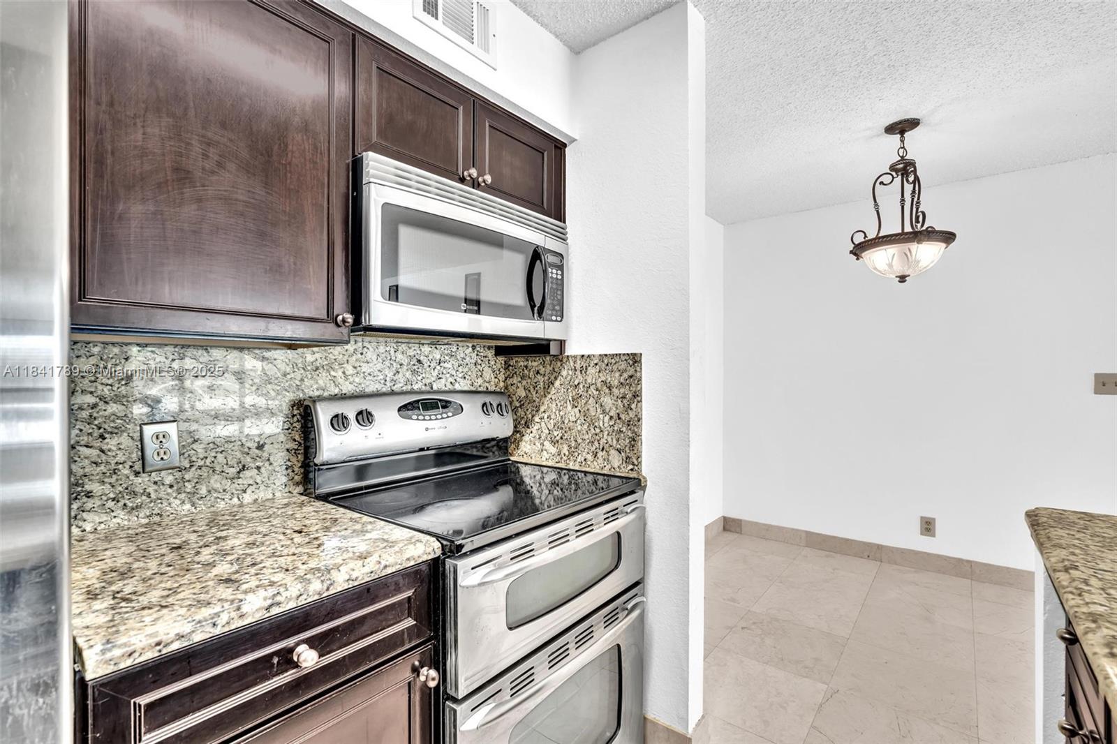 2796 South University Drive, Unit 2104 Davie, FL 33328 - Photo 12 of 41 a kitchen with a stove and a microwave