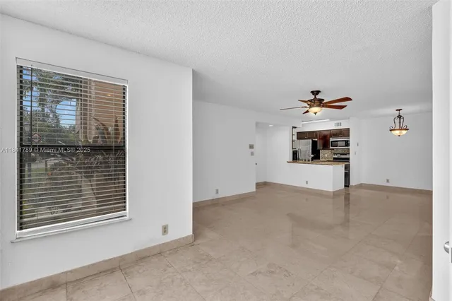 a view of a livingroom with wooden floor and a ceiling fan