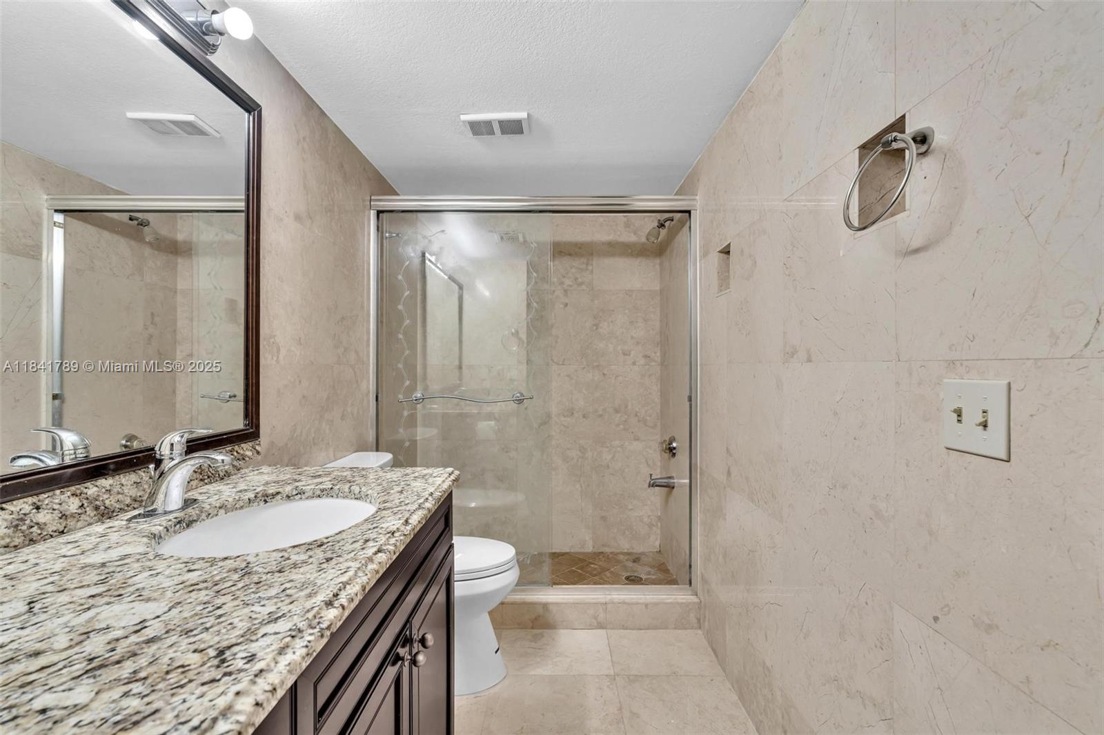 2796 South University Drive, Unit 2104 Davie, FL 33328 - Photo 24 of 41 a bathroom with a granite countertop sink a toilet and shower