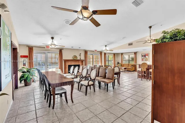 a dining room with furniture potted plants and wooden floor