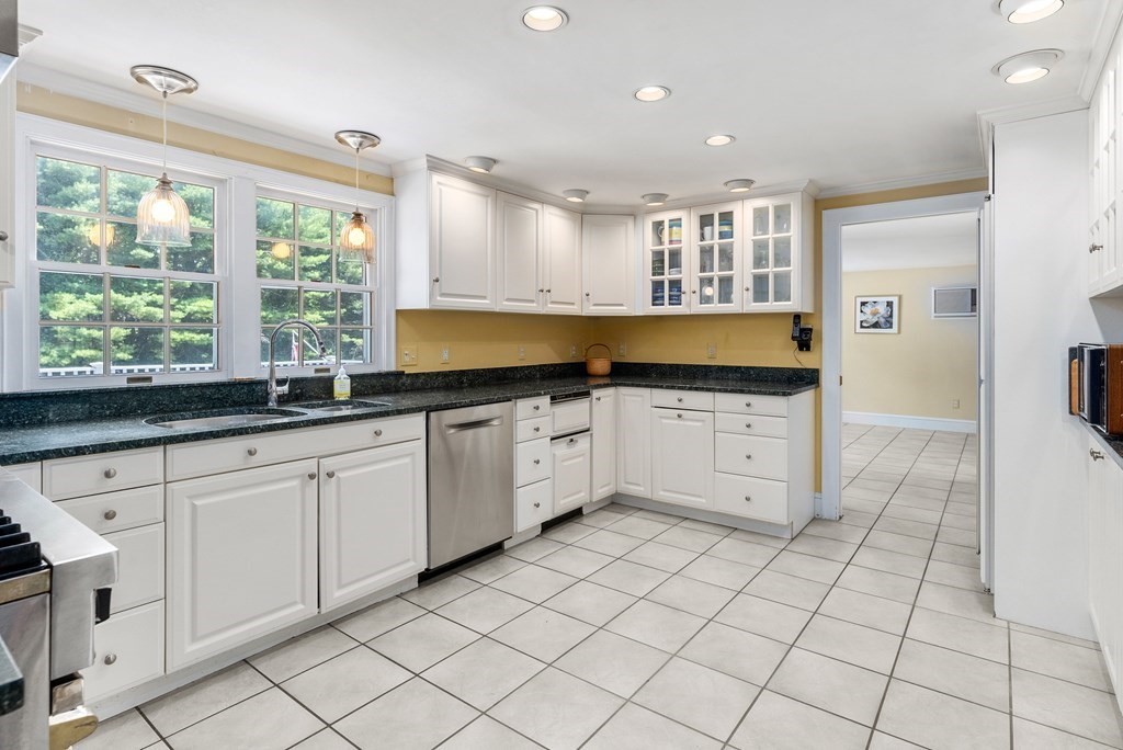 29 Sunset Road Weston, MA 02493 - Photo 9 of 29 a large kitchen with white cabinets a sink a window and a refrigerator