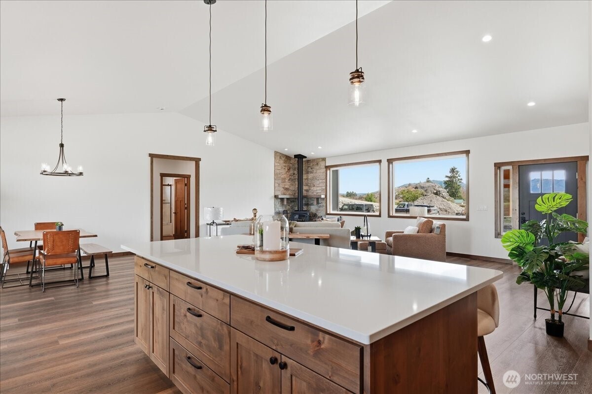 110 Slide View Lane Manson, WA 98831 - Photo 15 of 38 a kitchen with granite countertop a sink dishwasher and a dining table with wooden floor