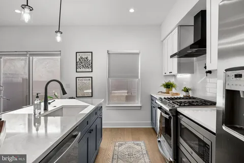 a kitchen with stainless steel appliances granite countertop a sink stove and cabinets