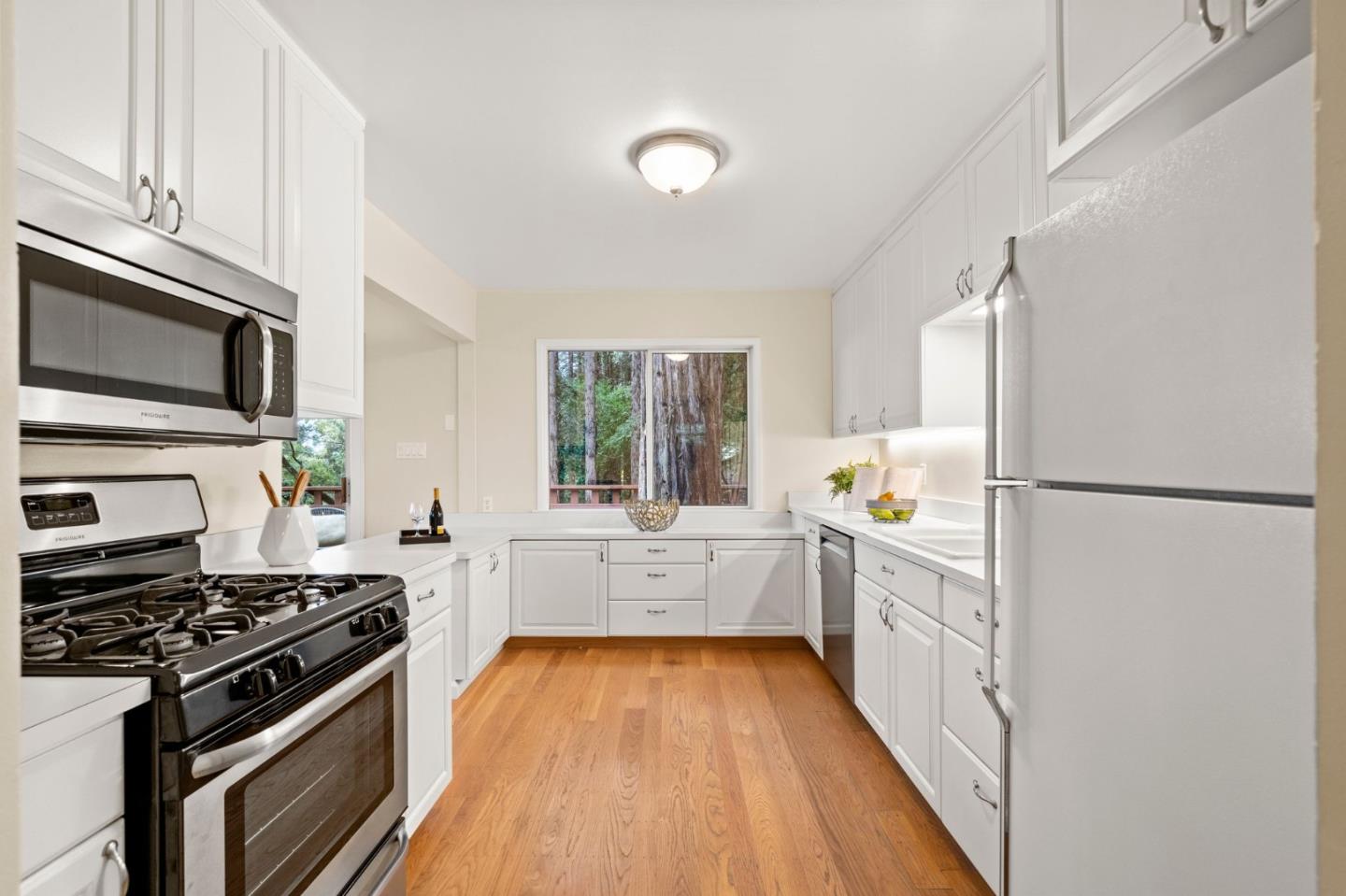 555 Summit Spring Road Woodside, CA 94062 - Photo 23 of 90 a kitchen with stainless steel appliances a stove top oven a sink a refrigerator white cabinets and wooden floor