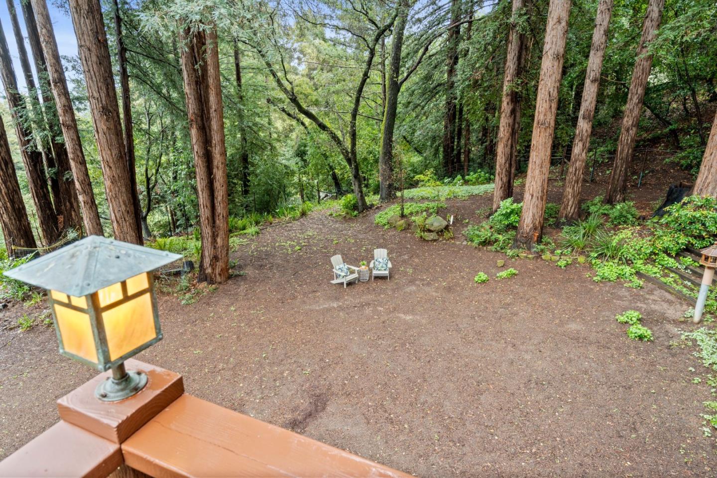 555 Summit Spring Road Woodside, CA 94062 - Photo 66 of 90 a backyard of a house with table and chairs under an umbrella