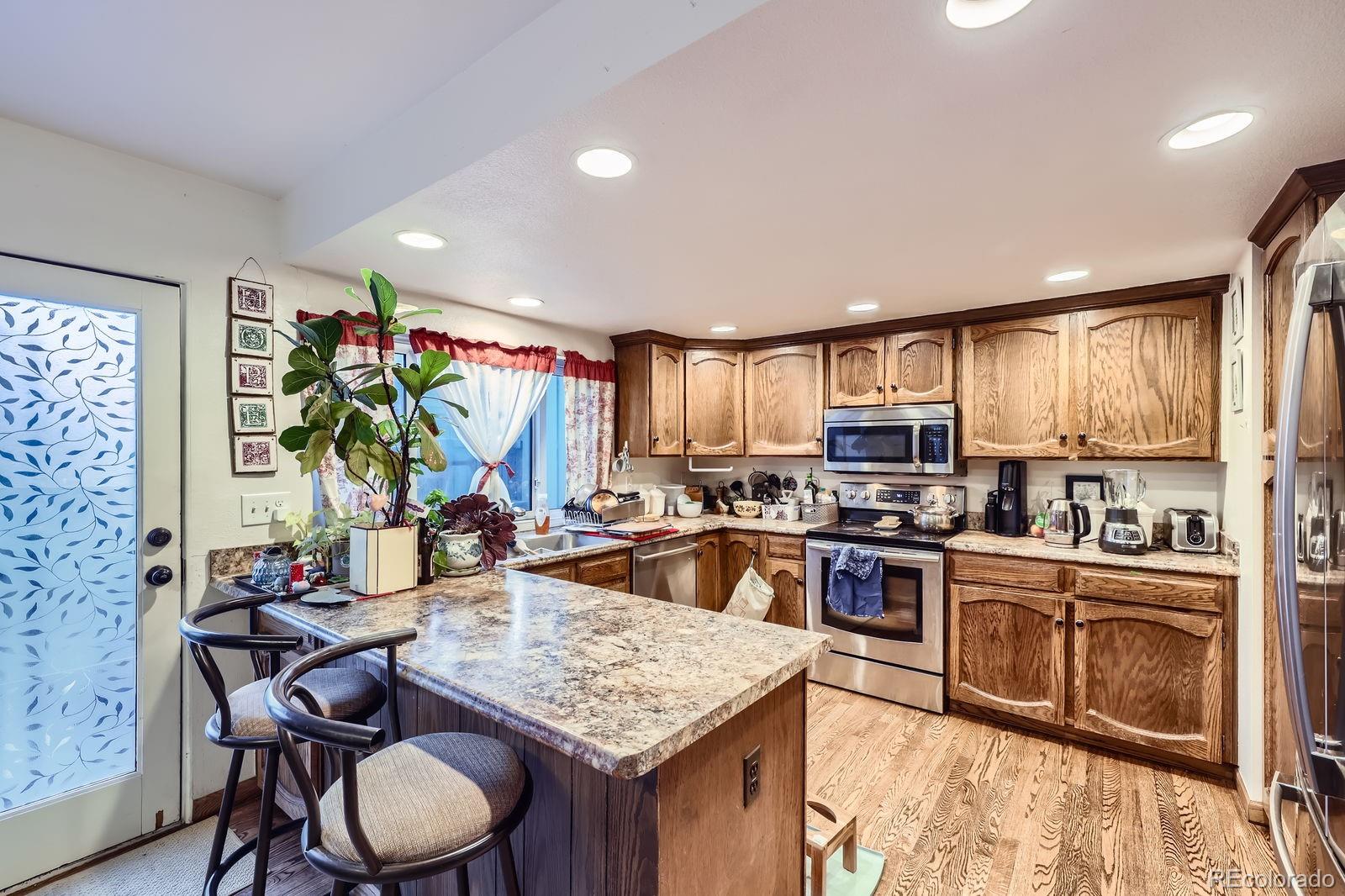 7920 East Phillips Circle Centennial, CO 80112 - Photo 4 of 13 a kitchen with sink refrigerator dining table and chairs
