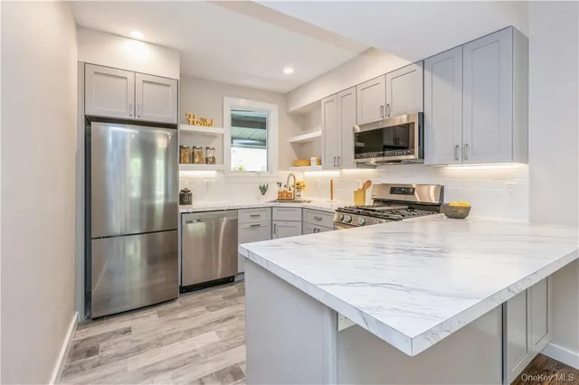 a kitchen with stainless steel appliances granite countertop a refrigerator stove microwave and sink