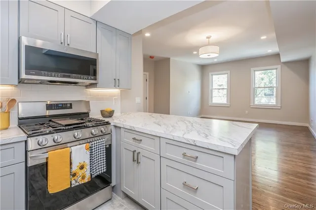 a kitchen with stainless steel appliances granite countertop a stove a microwave and a sink