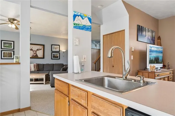 a kitchen with a sink a counter top space and living room view