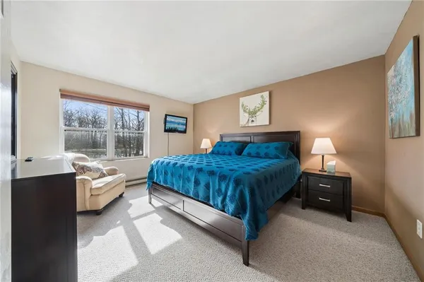 a spacious bedroom with a bed and a large window