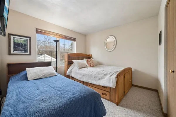 a bedroom with two beds and wooden floor