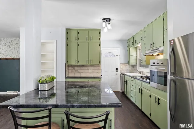 a kitchen with kitchen island a sink stove and refrigerator