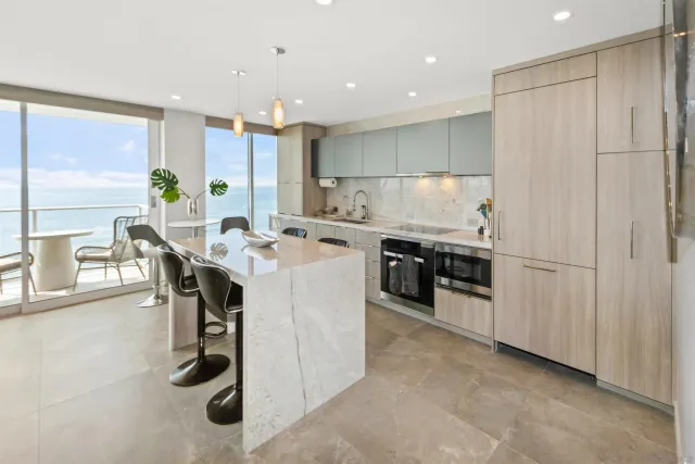 a kitchen with stainless steel appliances a table and chairs