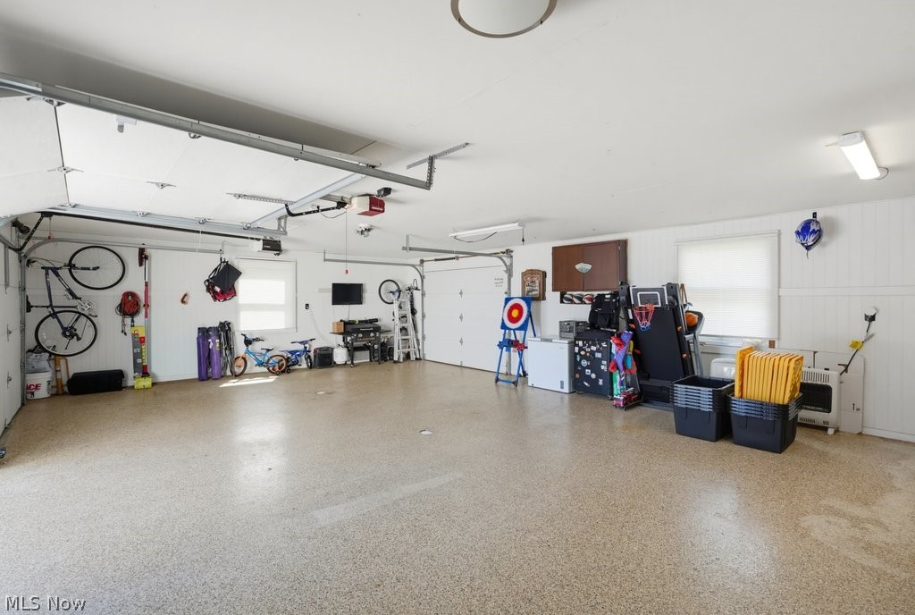 23055 Snell Road Columbia Station, OH 44028 - Photo 41 of 50 Spacious garage featuring two overhead doors, a speckled epoxy-coated concrete floor, and white paneled walls