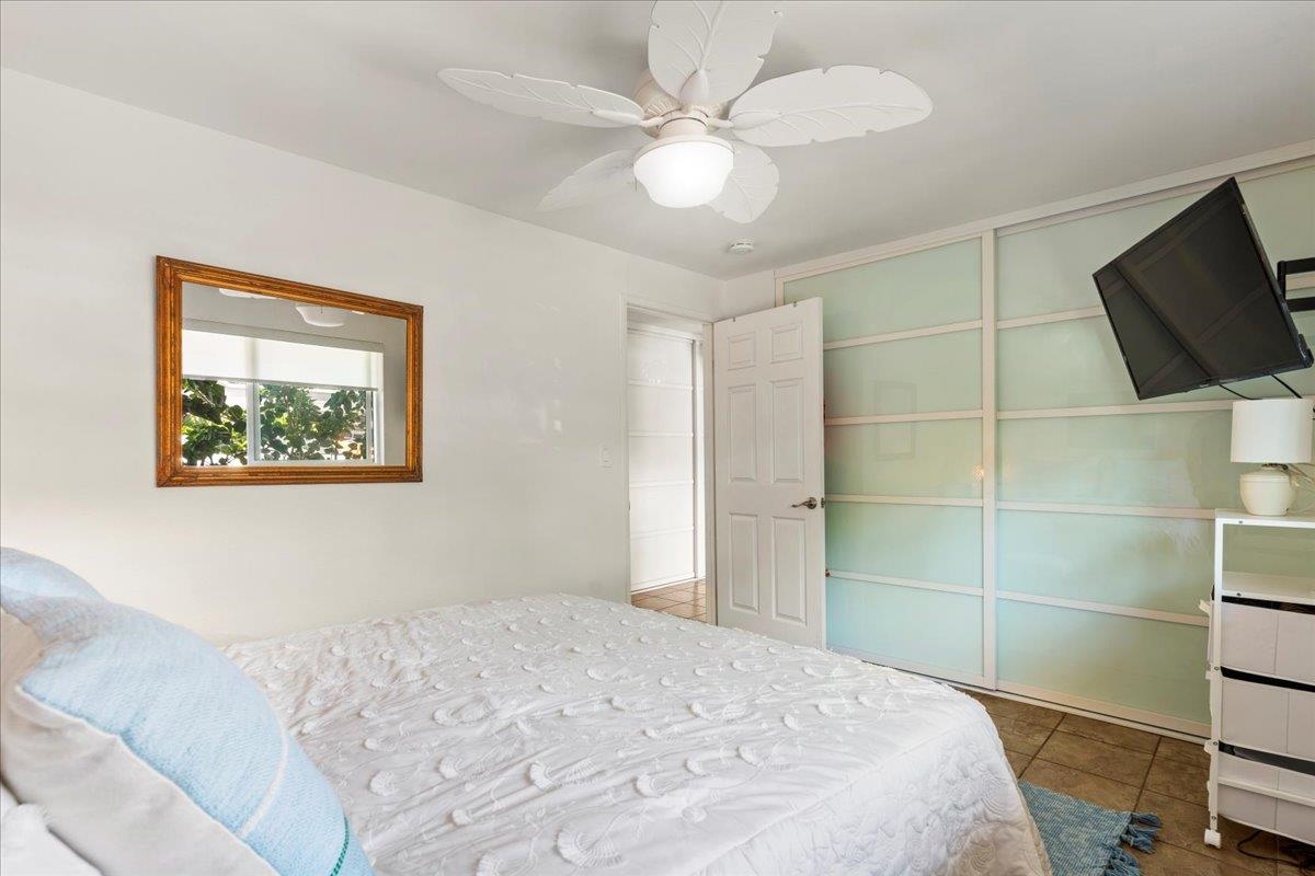 2747 South Kihei Road, Unit E104 Kihei, HI 96753 - Photo 27 of 49 a bedroom with a large bed and a flat screen tv