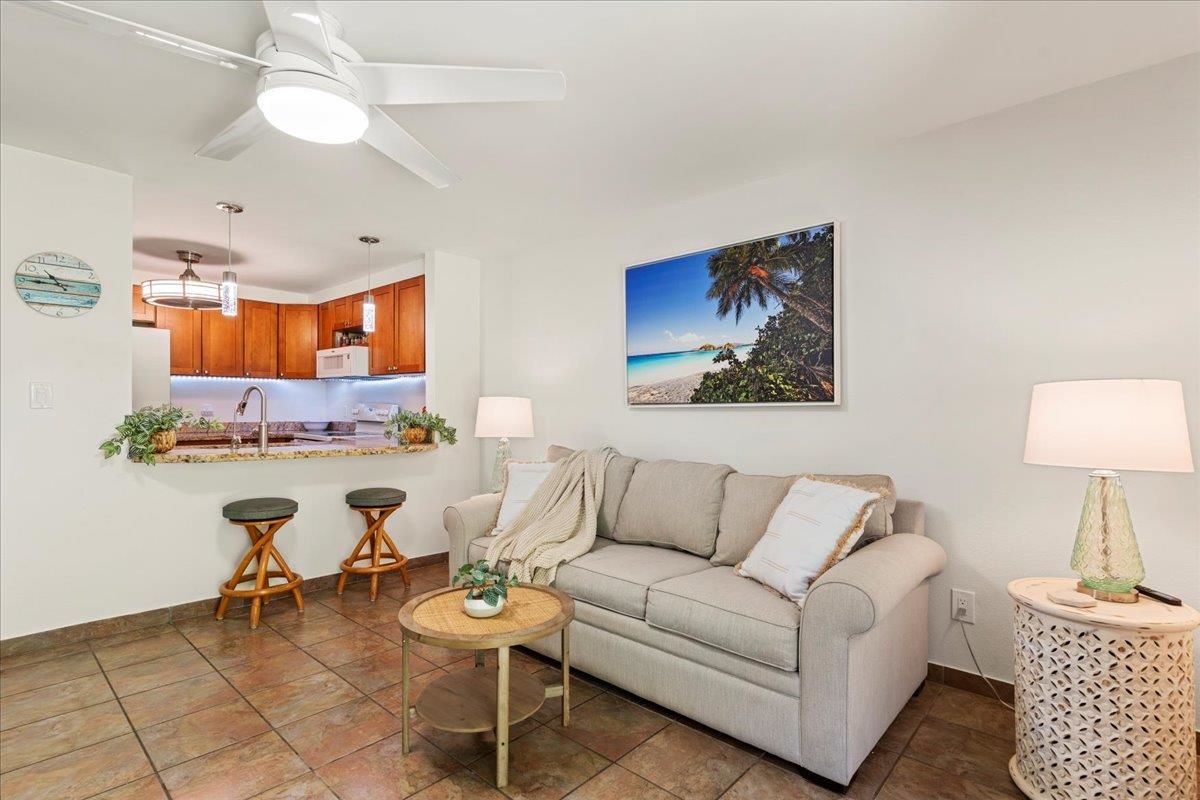 2747 South Kihei Road, Unit E104 Kihei, HI 96753 - Photo 38 of 49 a living room with furniture a rug and a chandelier