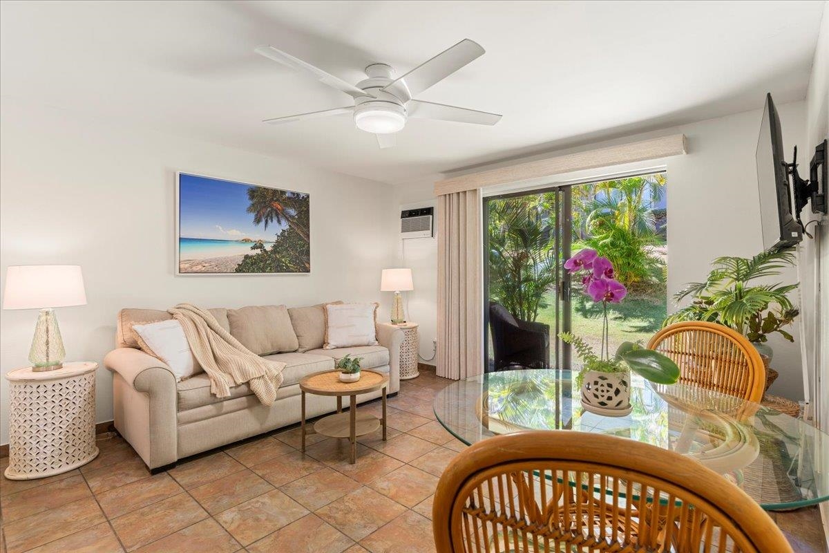 2747 South Kihei Road, Unit E104 Kihei, HI 96753 - Photo 4 of 49 a living room with furniture a chandelier and a window