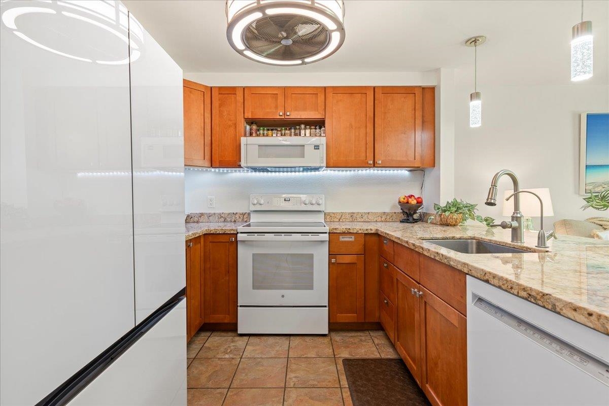 2747 South Kihei Road, Unit E104 Kihei, HI 96753 - Photo 41 of 49 a kitchen with stainless steel appliances granite countertop a sink and a stove next to a window