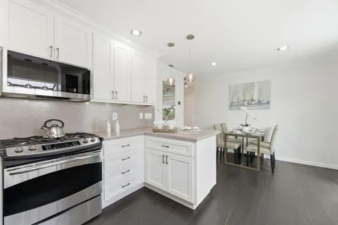 a kitchen with a stove and white cabinets