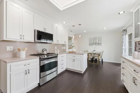 a kitchen with granite countertop white cabinets and appliances