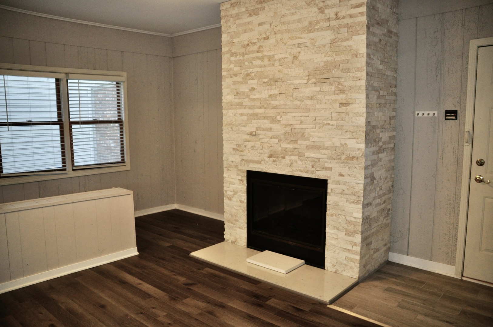 110 West 12th Avenue Naperville, IL 60563 - Photo 11 of 21 an empty room with wooden floor and fireplace