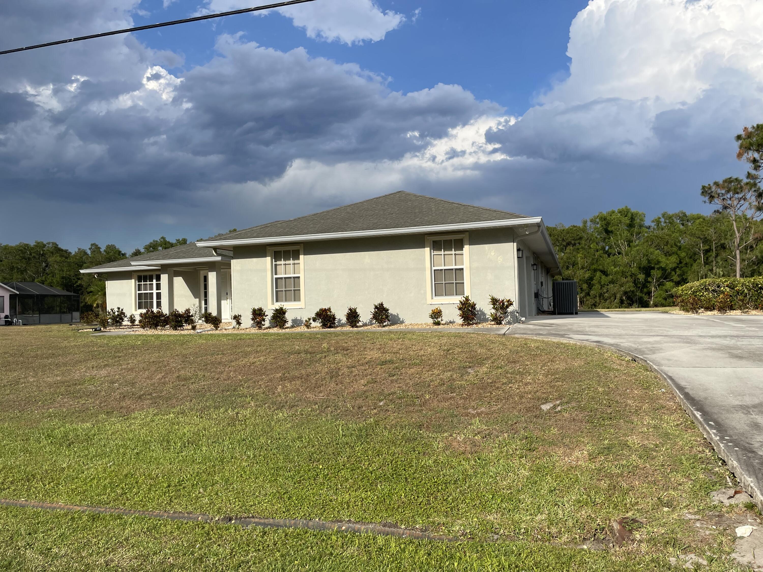 145 Southwest Hawthorne Circle Port St. Lucie, FL 34953 - Photo 1 of 37 a front view of a house with a garden