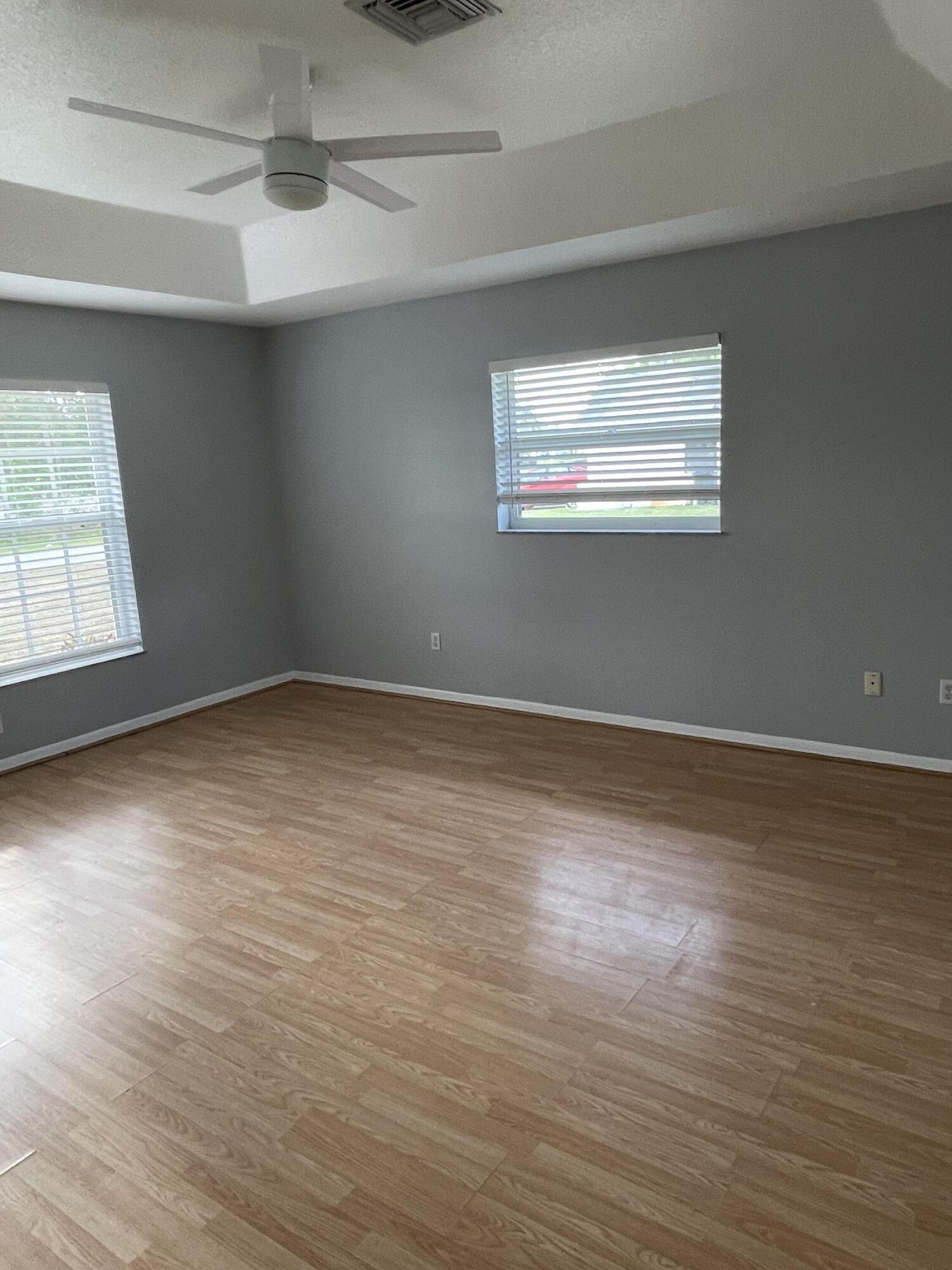 145 Southwest Hawthorne Circle Port St. Lucie, FL 34953 - Photo 11 of 37 an empty room with wooden floor and windows