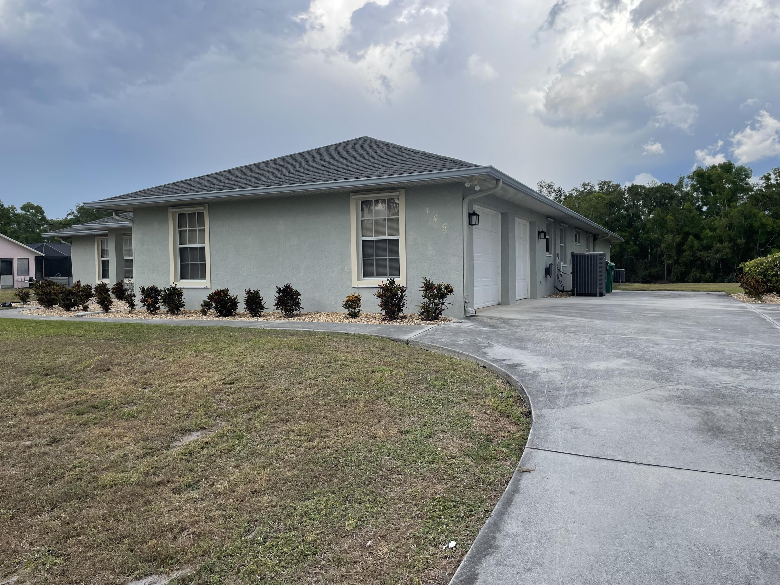 145 Southwest Hawthorne Circle Port St. Lucie, FL 34953 - Photo 2 of 37 a front view of a house with a garden
