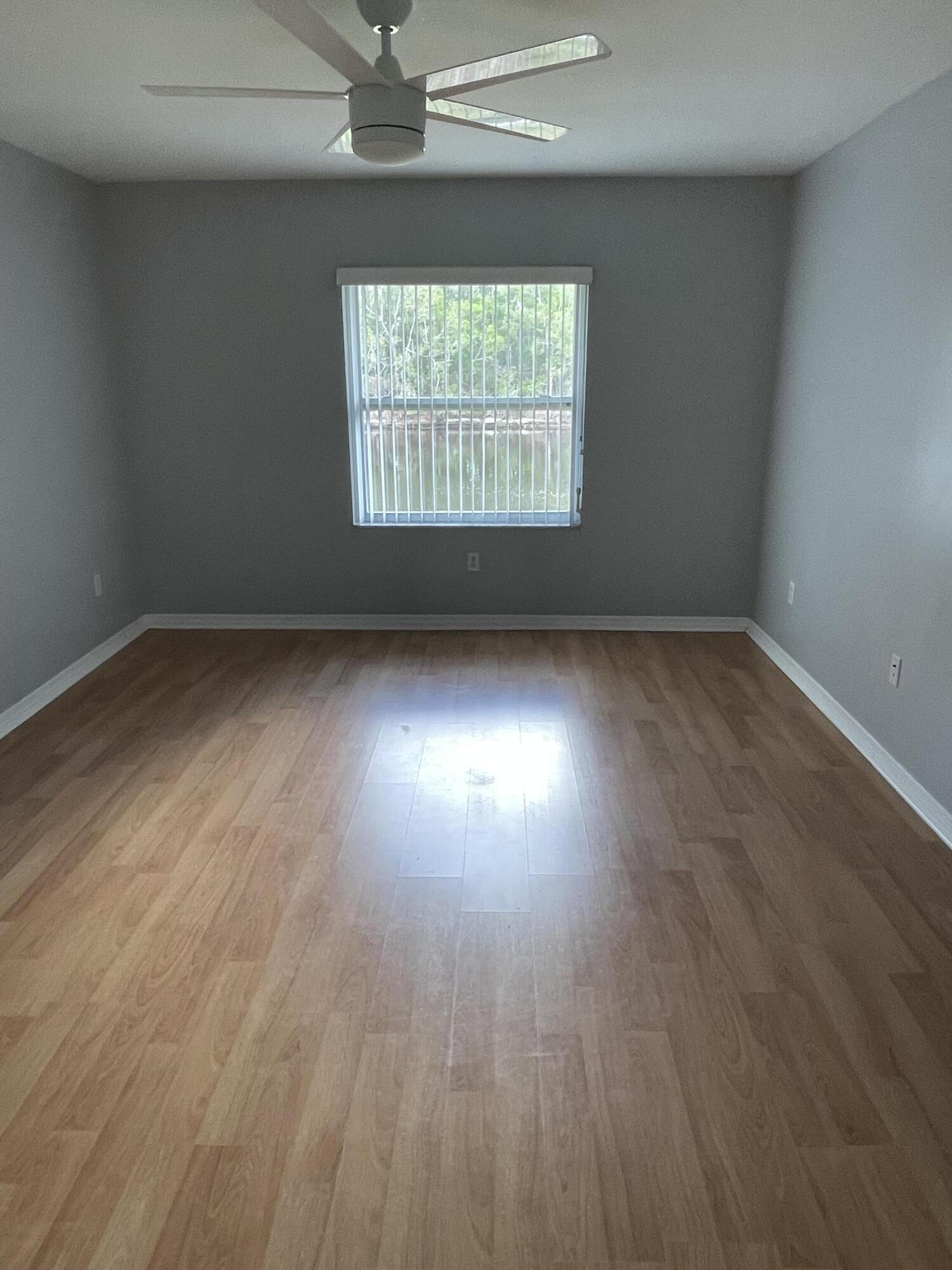145 Southwest Hawthorne Circle Port St. Lucie, FL 34953 - Photo 22 of 37 an empty room with wooden floor and windows