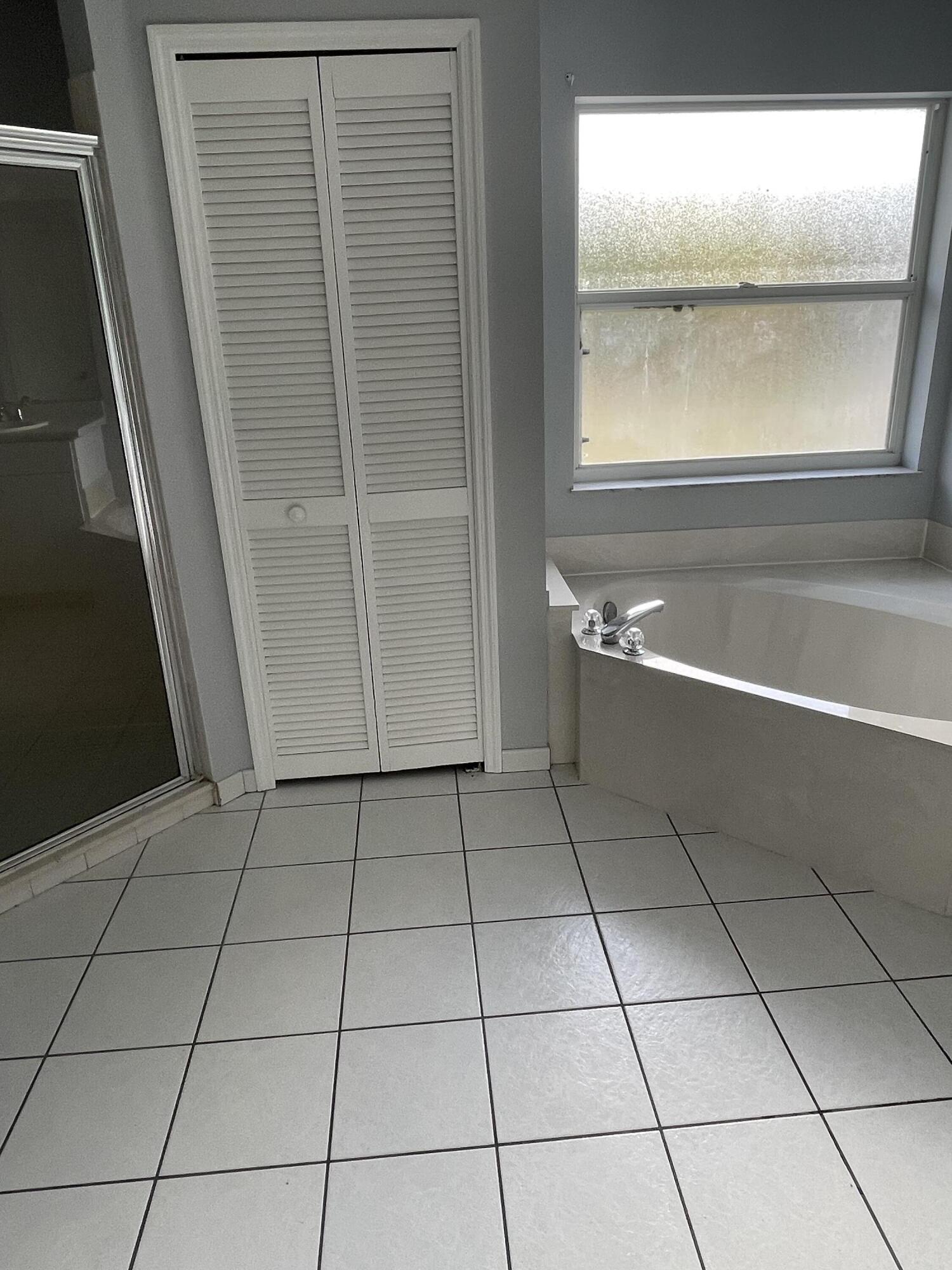 145 Southwest Hawthorne Circle Port St. Lucie, FL 34953 - Photo 29 of 37 a bathroom with a bathtub and window