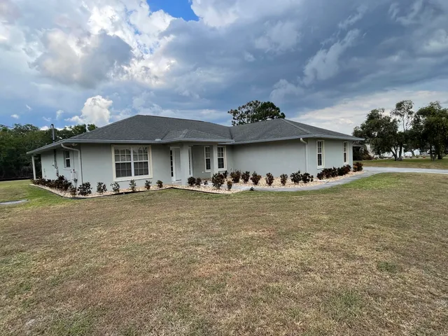 a view of a house with a yard and sitting area
