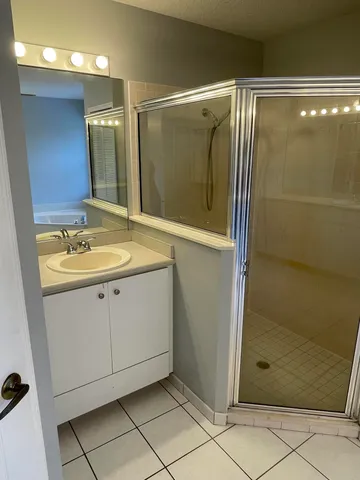 a bathroom with a shower sink and mirror