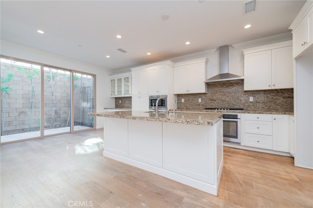 103 Tidal Irvine, CA 92620 - Photo 6 of 25 a large kitchen with kitchen island a sink stainless steel appliances and cabinets