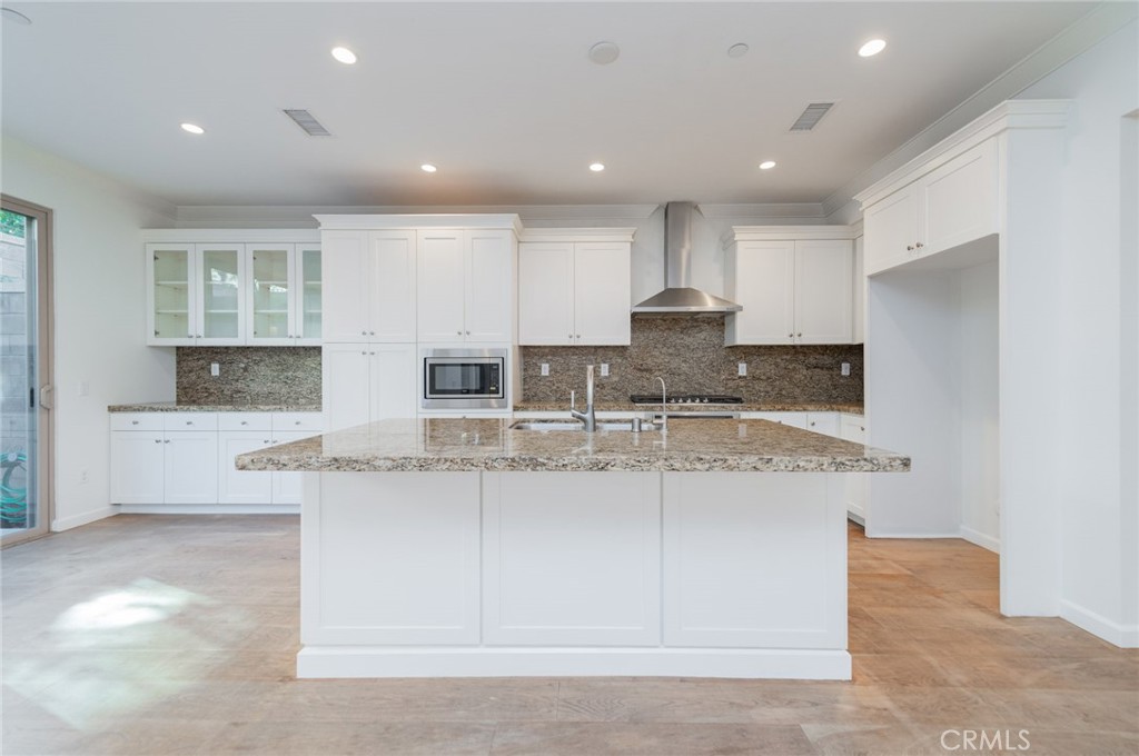 103 Tidal Irvine, CA 92620 - Photo 7 of 25 a kitchen with stainless steel appliances granite countertop a stove top oven a sink a refrigerator and white cabinets