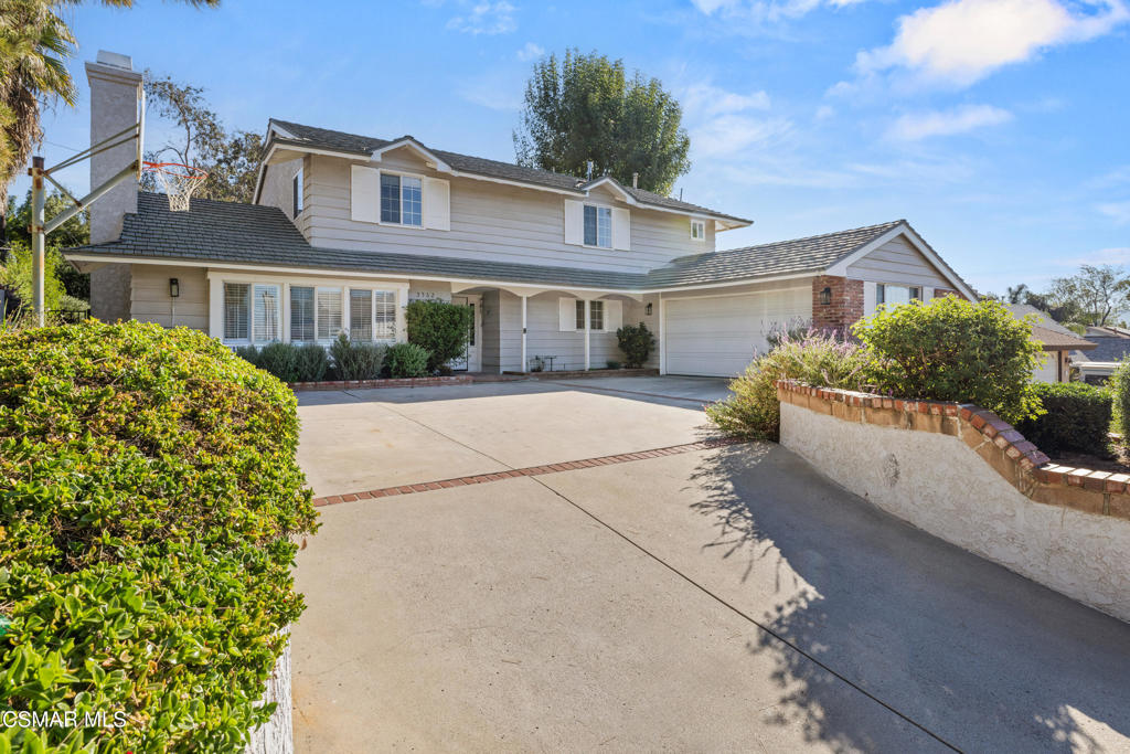 a front view of a house with a yard and potted plants