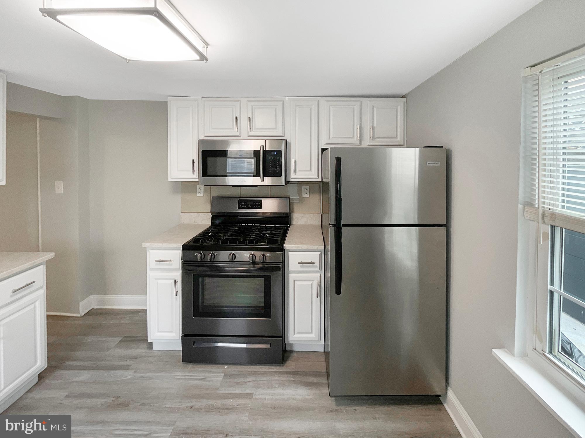 160 McClellan Street Philadelphia, PA 19148 - Photo 3 of 29 a kitchen with stainless steel appliances a refrigerator stove and microwave