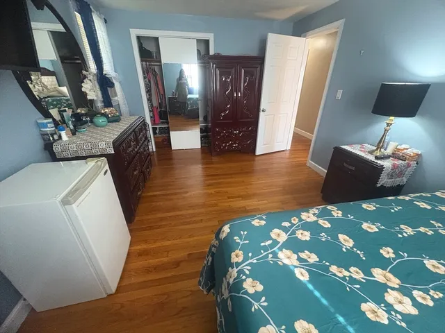 a bedroom with a bed and a flat tv screen on dresser