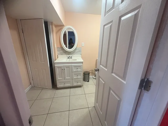 a bathroom with a sink a toilet a mirror and shower