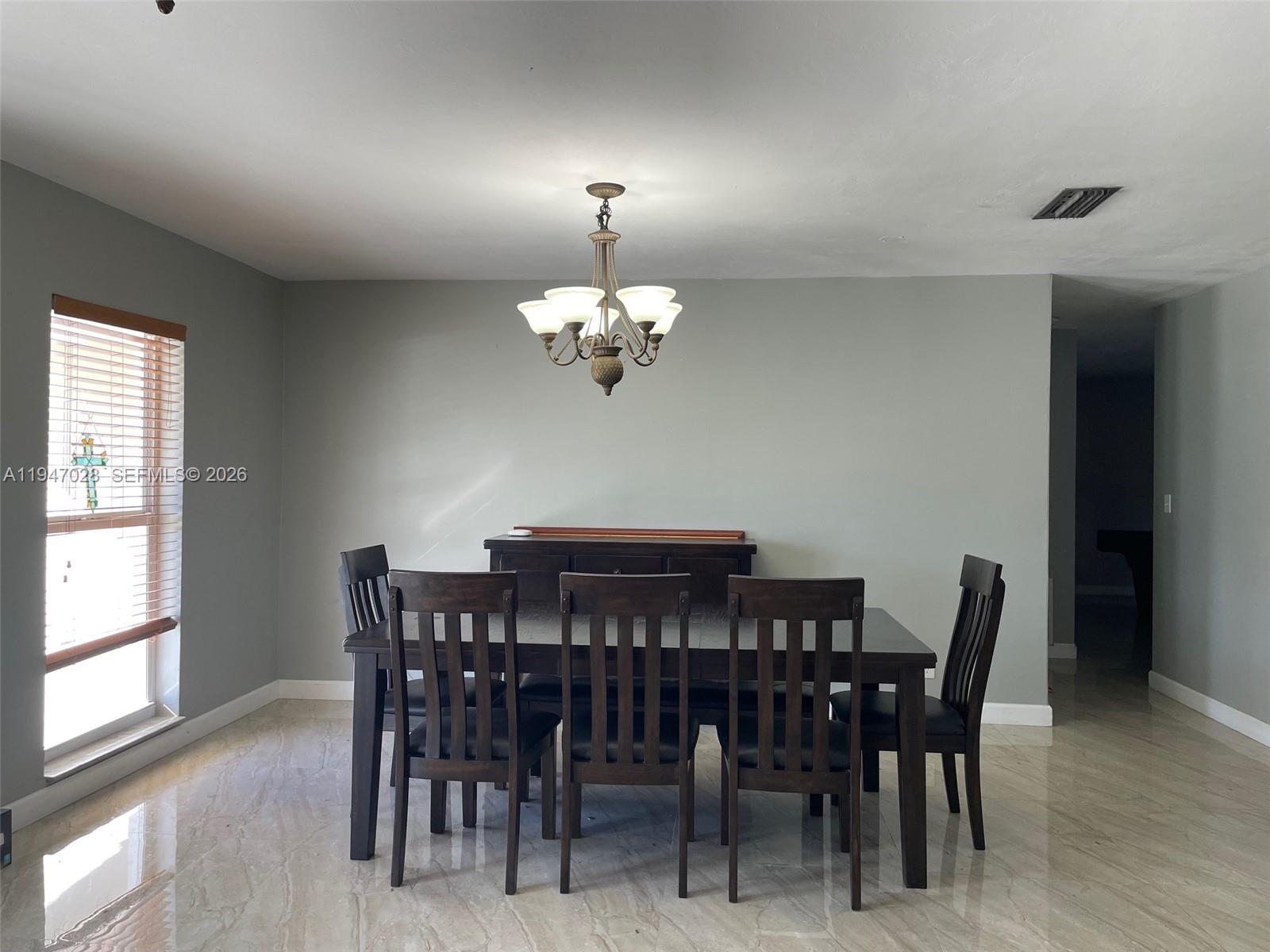 14503 Southwest 84th Street Miami, FL 33143 - Photo 11 of 23 a view of a dining room with furniture and chandelier