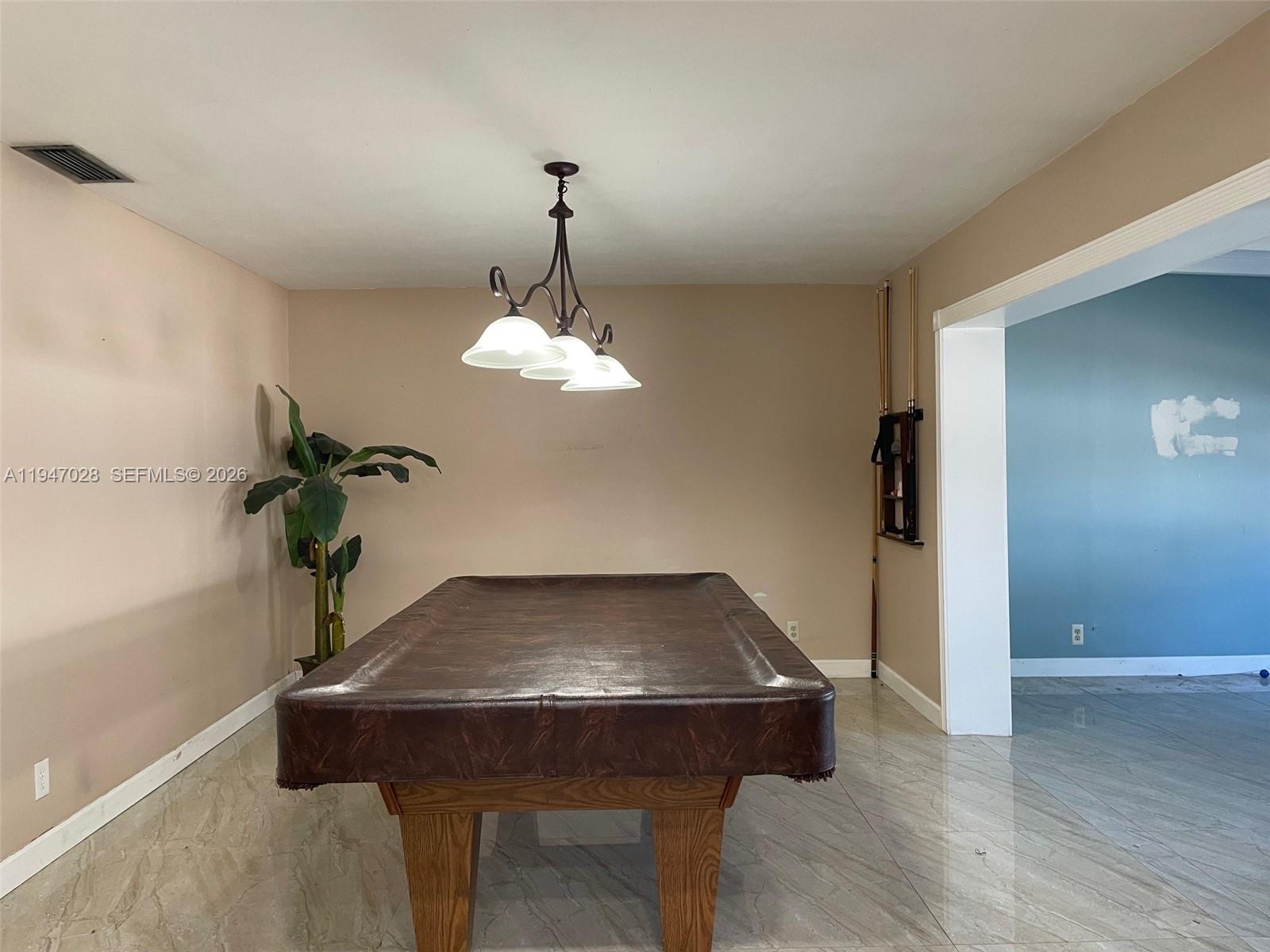 14503 Southwest 84th Street Miami, FL 33143 - Photo 12 of 23 a view of a room with a table and chandelier