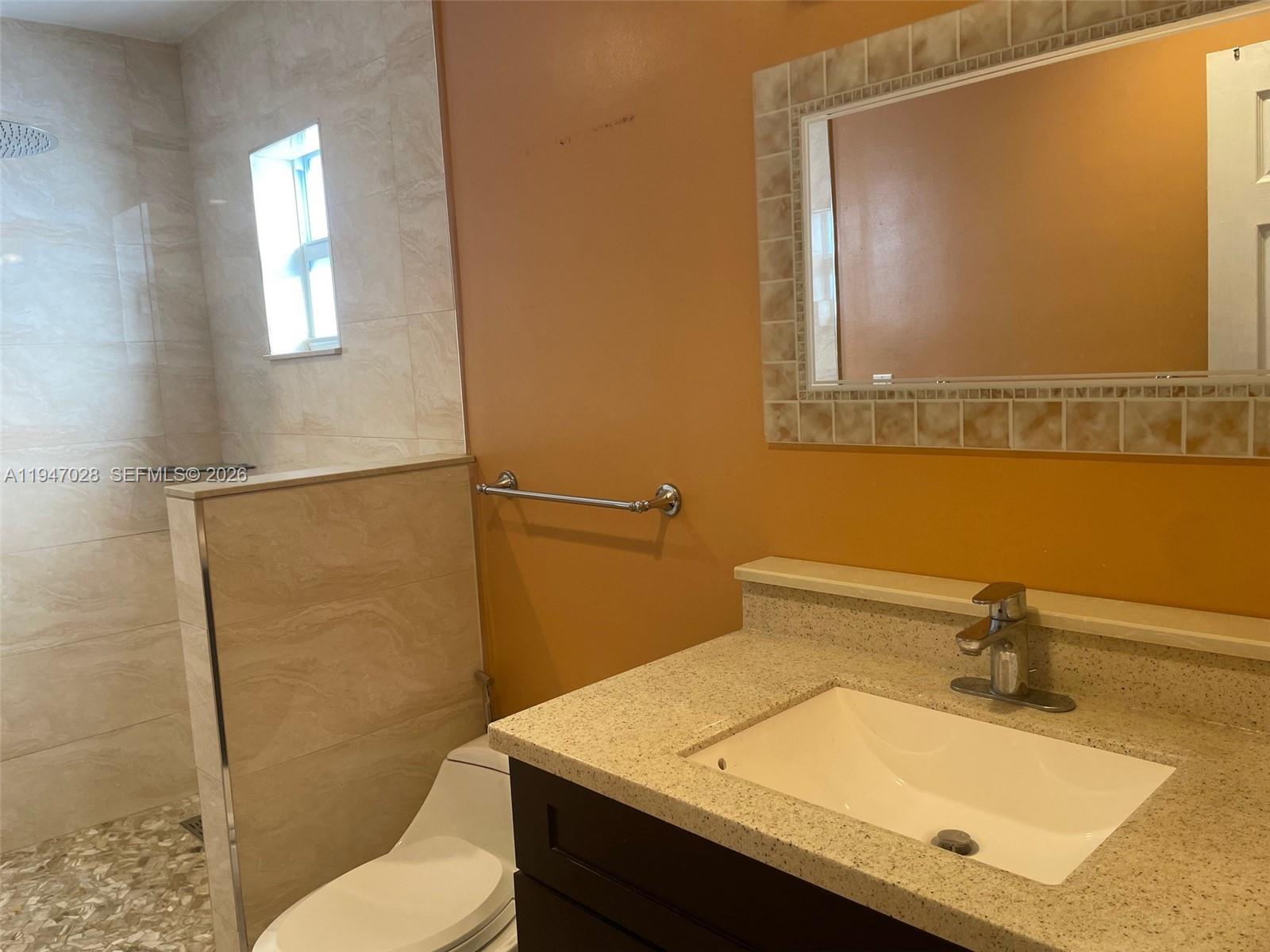 14503 Southwest 84th Street Miami, FL 33143 - Photo 13 of 23 a bathroom with a sink a toilet and mirror