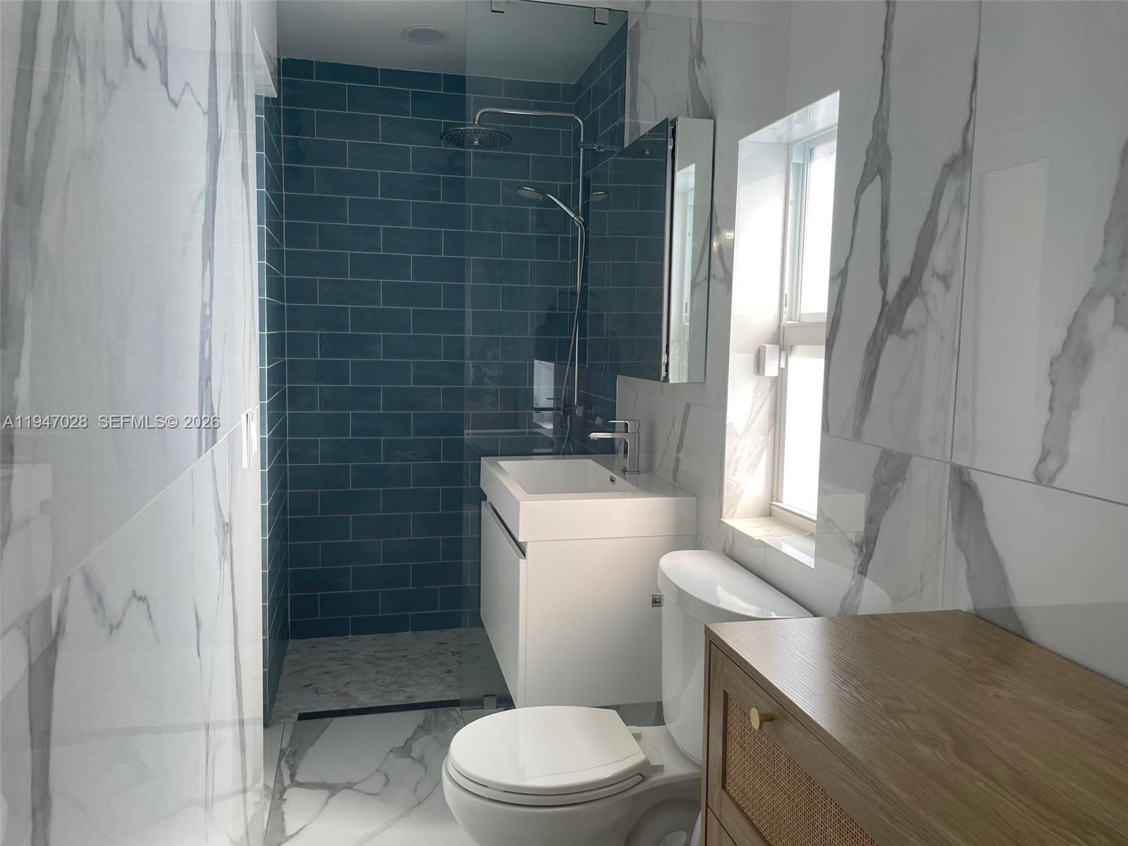 14503 Southwest 84th Street Miami, FL 33143 - Photo 17 of 23 a bathroom with a granite countertop toilet sink and shower