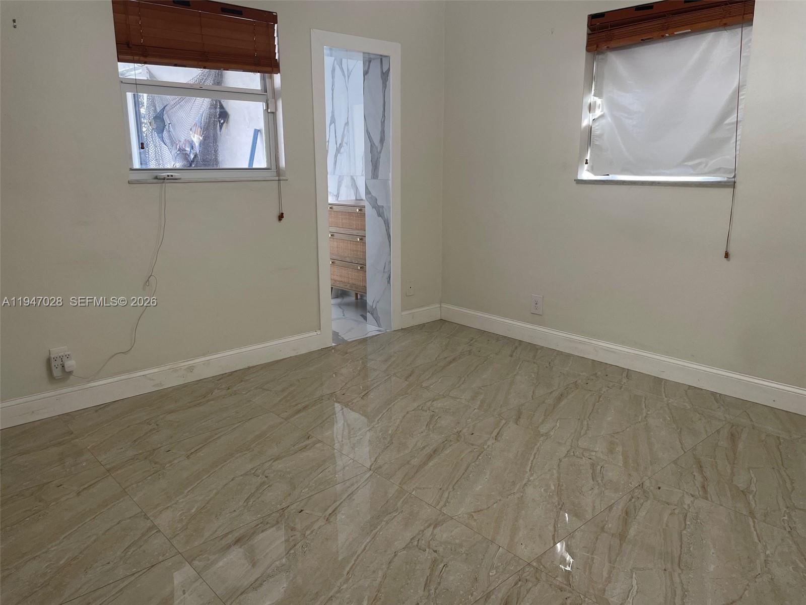 14503 Southwest 84th Street Miami, FL 33143 - Photo 19 of 23 an empty room with wooden floor and windows
