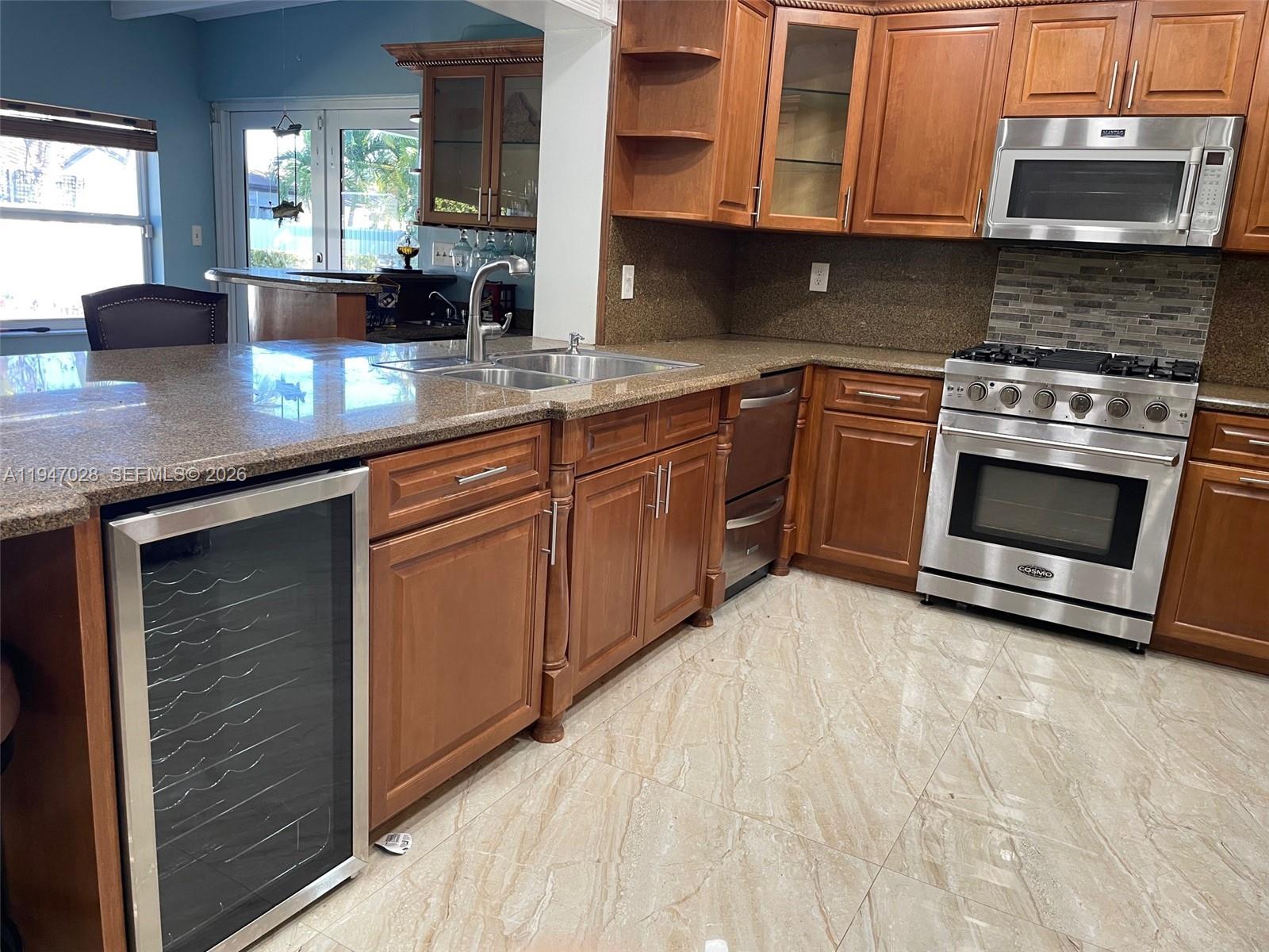 14503 Southwest 84th Street Miami, FL 33143 - Photo 22 of 23 a kitchen with stainless steel appliances granite countertop a stove a sink and a microwave