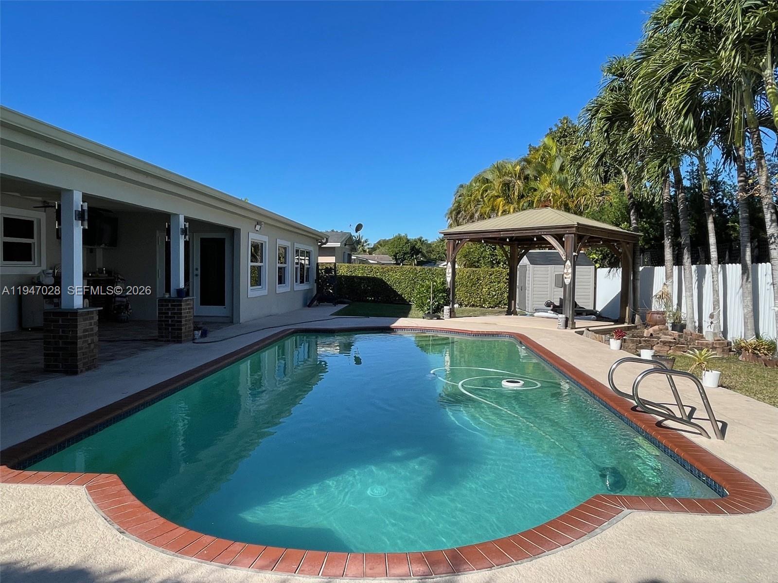14503 Southwest 84th Street Miami, FL 33143 - Photo 4 of 23 a swimming pool with outdoor seating yard and barbeque oven