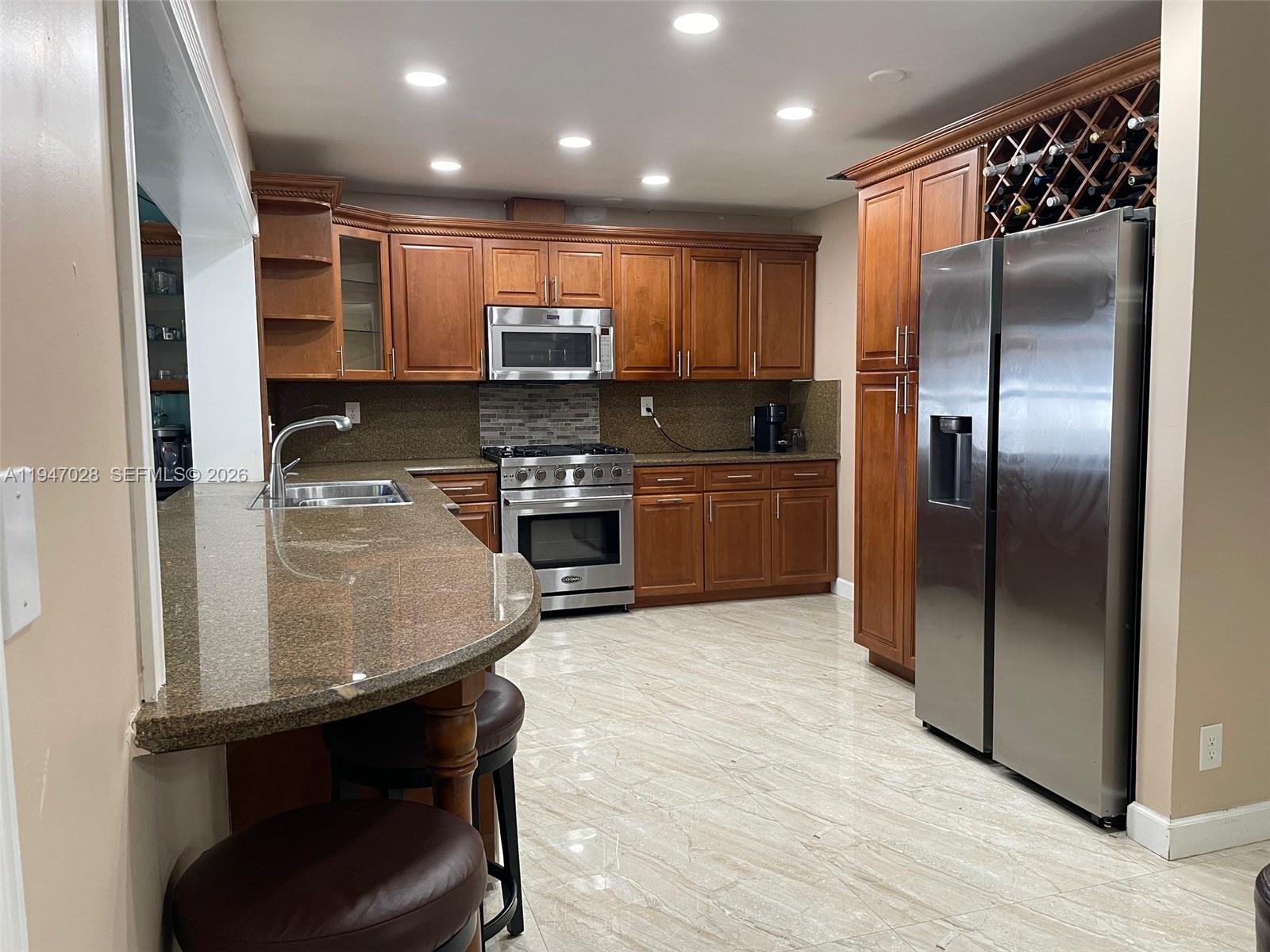 14503 Southwest 84th Street Miami, FL 33143 - Photo 7 of 23 a kitchen with stainless steel appliances granite countertop a sink refrigerator and microwave