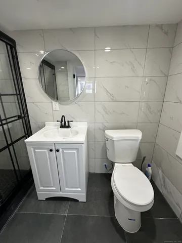 a bathroom with a sink a toilet and a mirror